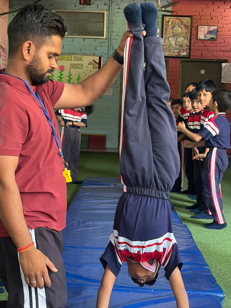 Coach supporting a student's handstand during gymnastics practice