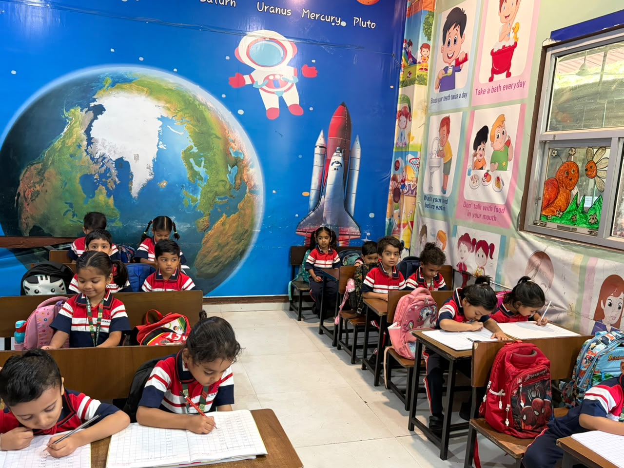 Junior Wing classroom with Earth and space wall mural during writing practice