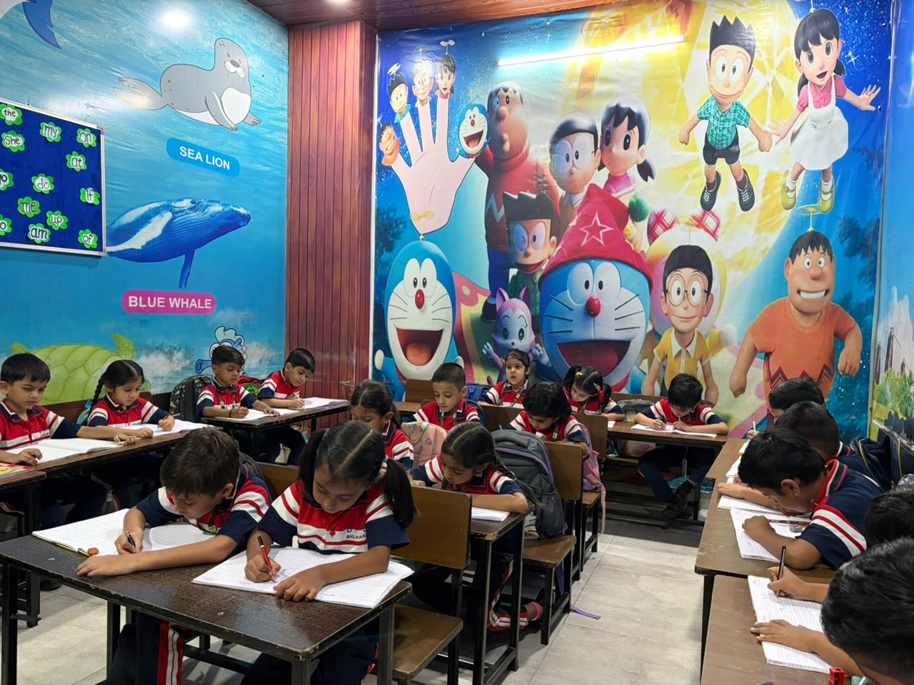 Students writing in notebooks in a cartoon mural classroom