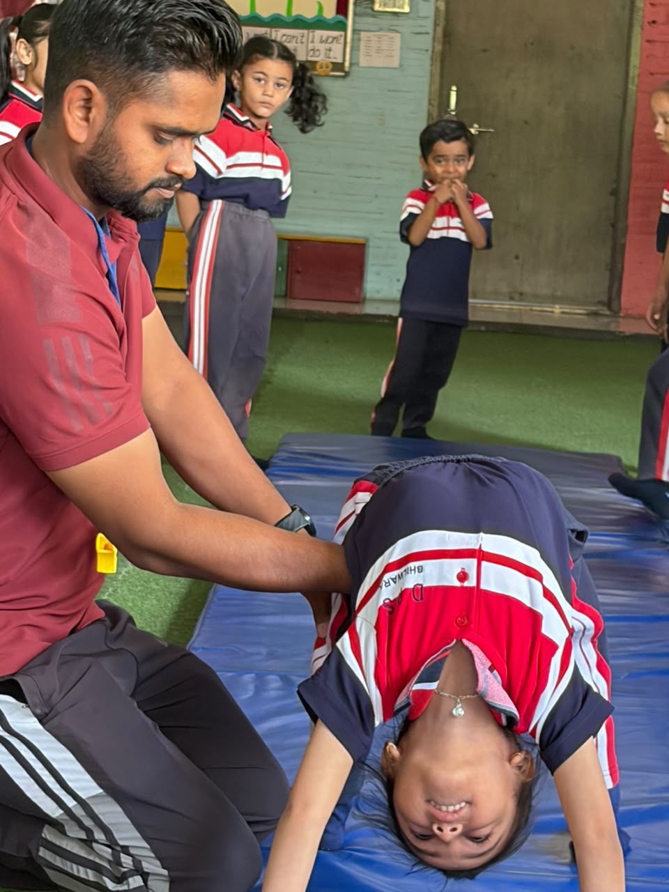 Coach guiding a student through a gymnastics backbend