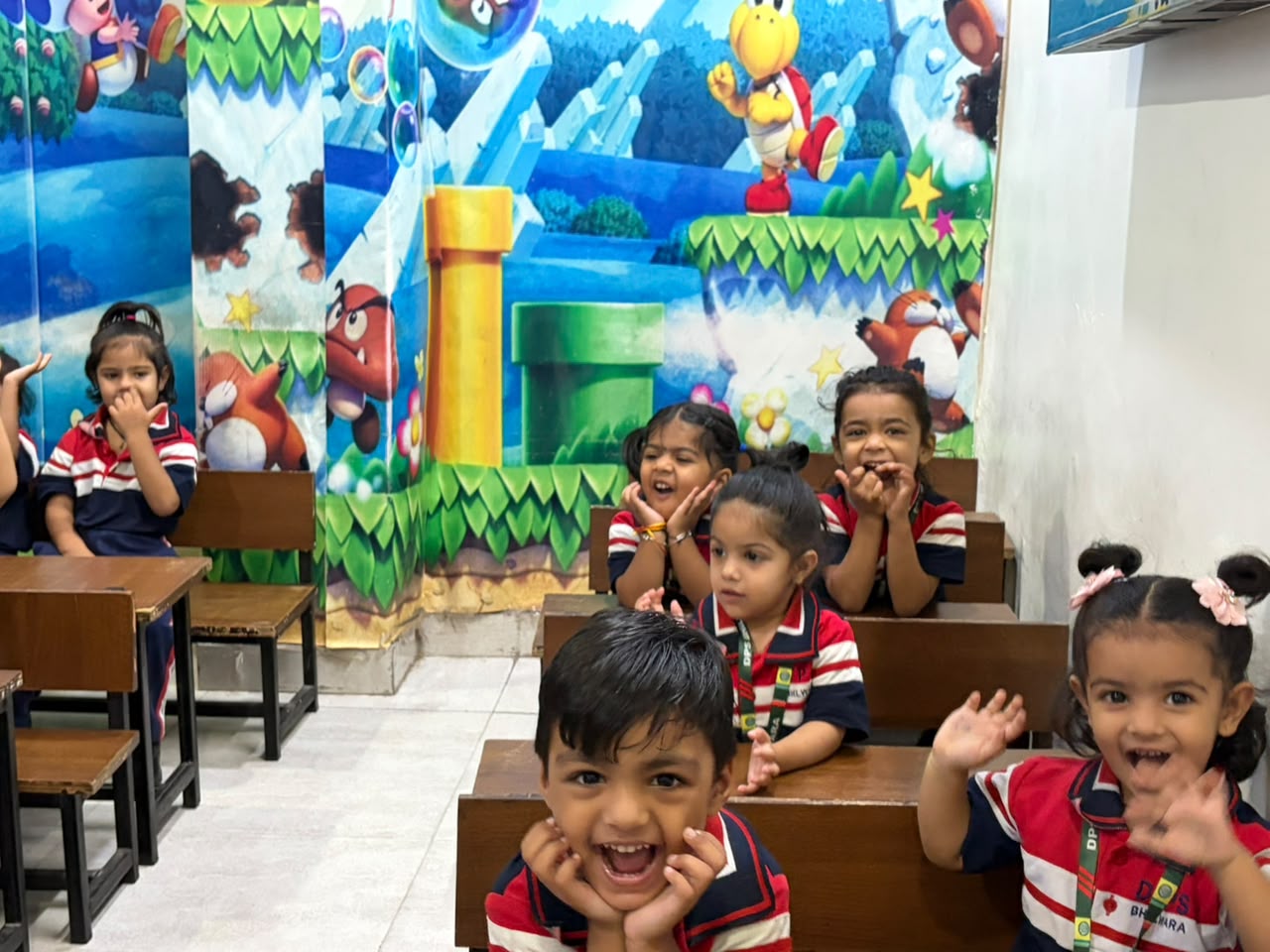Happy Junior Wing students laughing in a cartoon-themed classroom