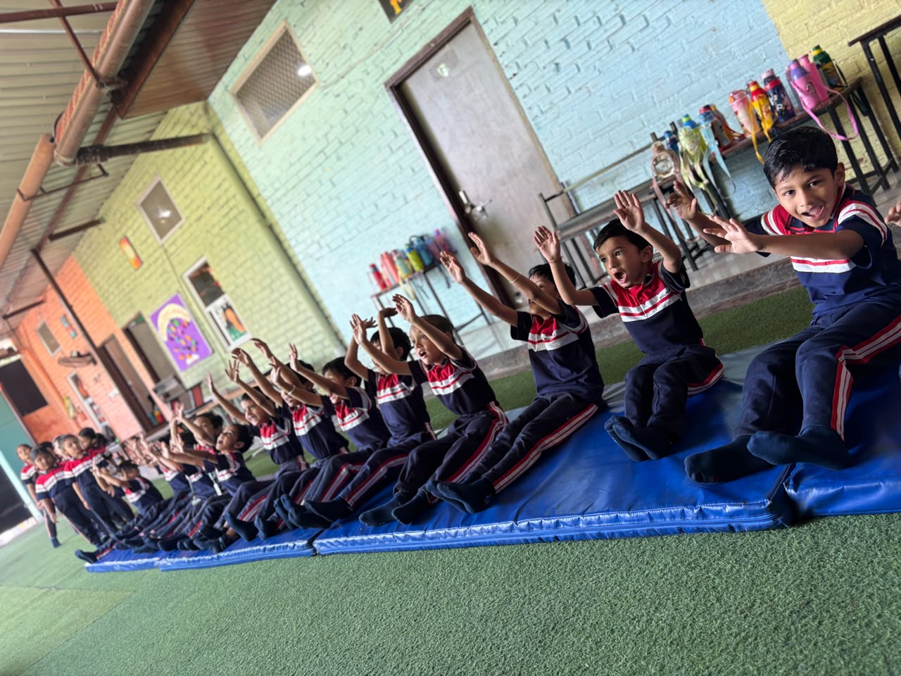Junior Wing students during a PT session on gym mats