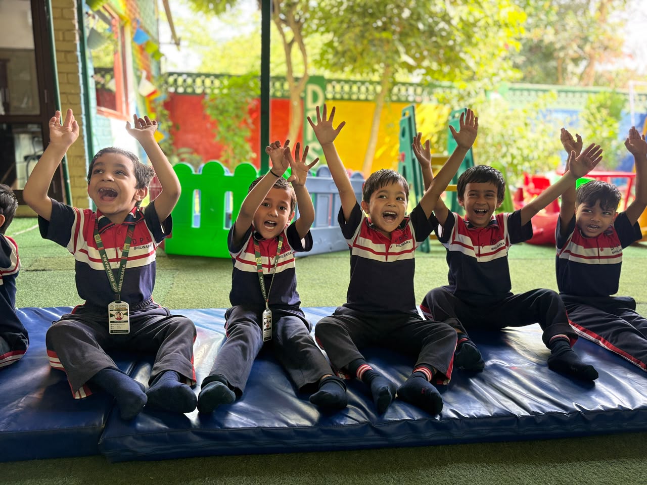 Junior Wing students smiling on gym mats in the play area