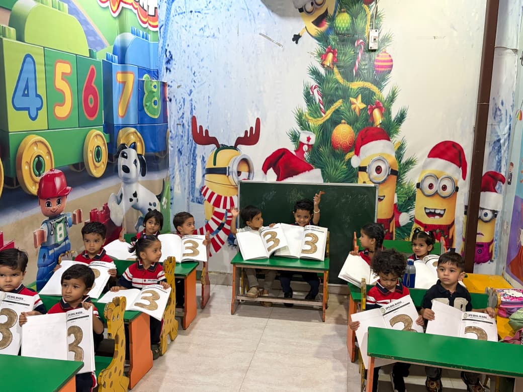 Students showing number 3 books in a Christmas-themed classroom at DPS Bhilwara